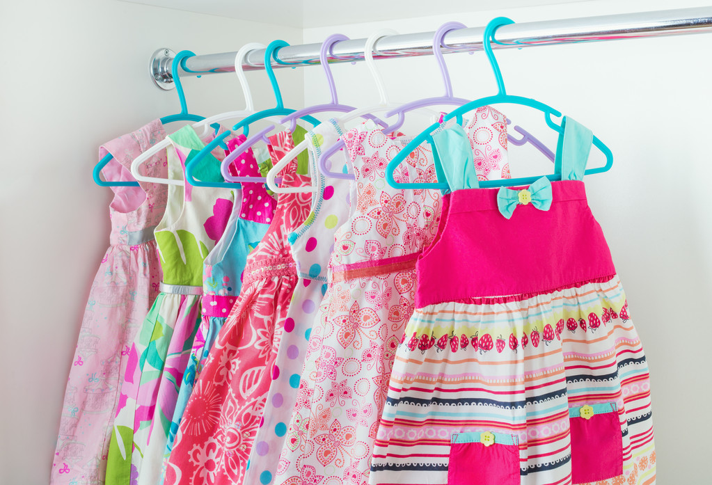 A closet filled with colorful dresses hanging on hangers. Get ready to learn sewing and tailoring skills at the Online Sewing Academy in India.