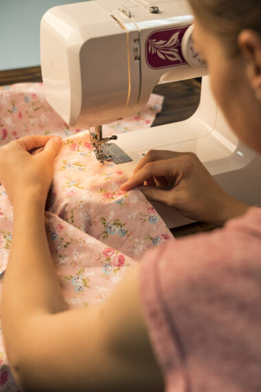 A woman sewing on a piece of fabric